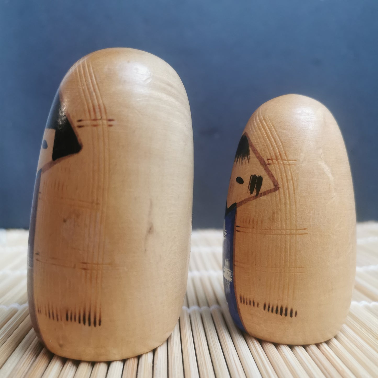 Joli duo de mini Kokeshi, représentant un frère et une sœur ou un parent et son enfant, vêtus de vêtements d'hiver