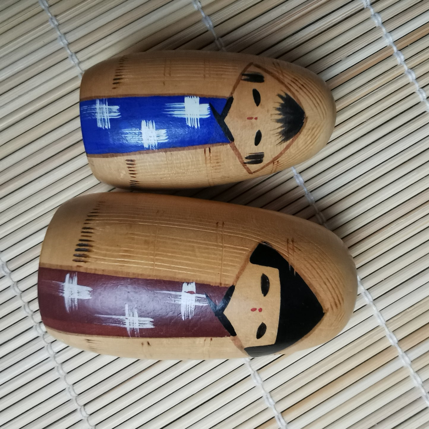 Joli duo de mini Kokeshi, représentant un frère et une sœur ou un parent et son enfant, vêtus de vêtements d'hiver