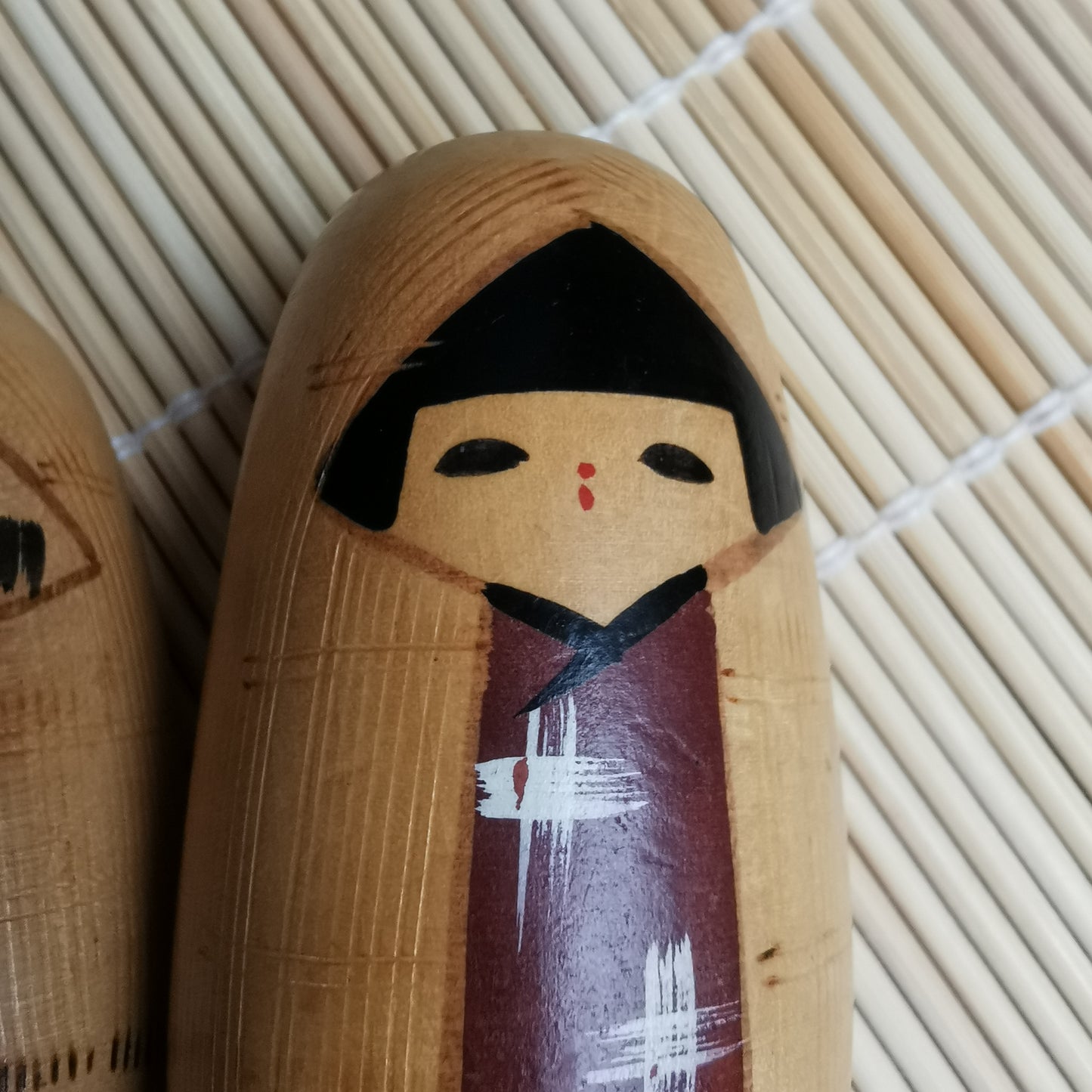 Joli duo de mini Kokeshi, représentant un frère et une sœur ou un parent et son enfant, vêtus de vêtements d'hiver