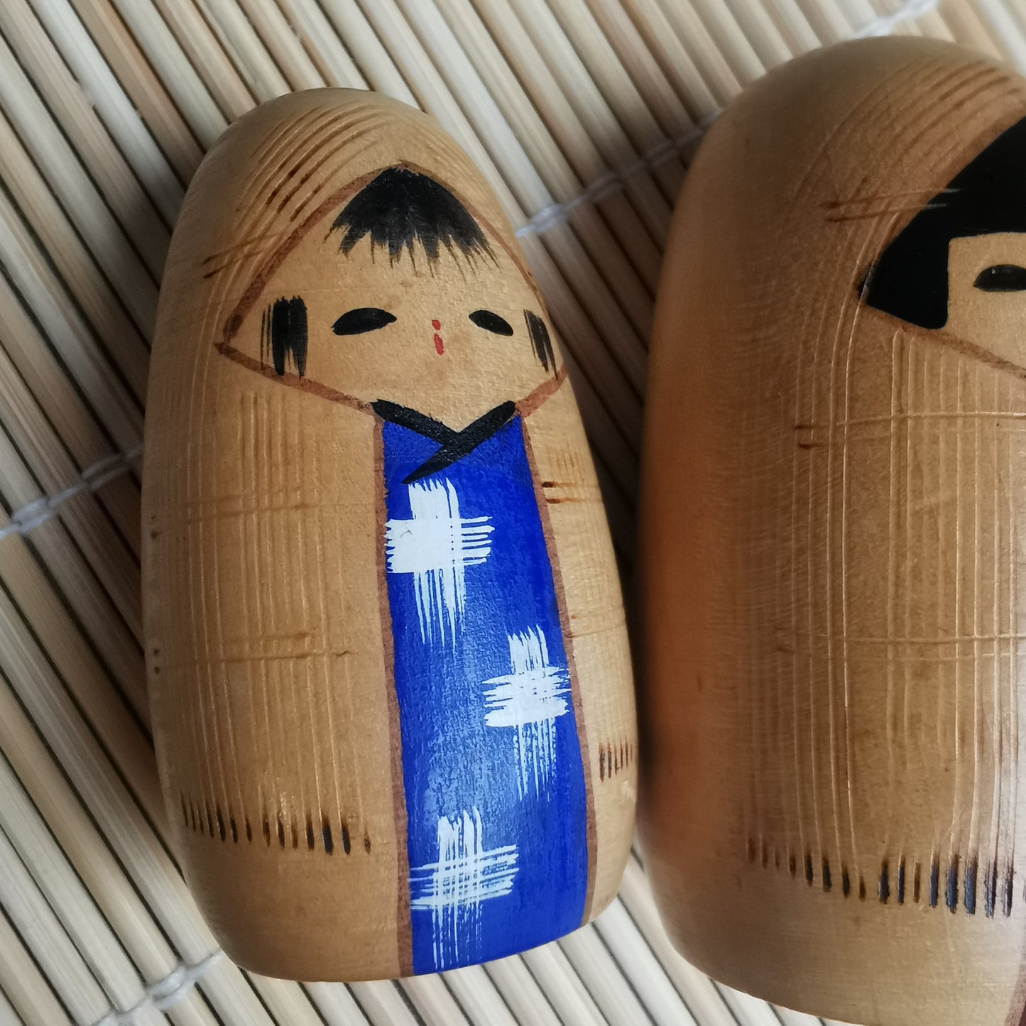 Joli duo de mini Kokeshi, représentant un frère et une sœur ou un parent et son enfant, vêtus de vêtements d'hiver